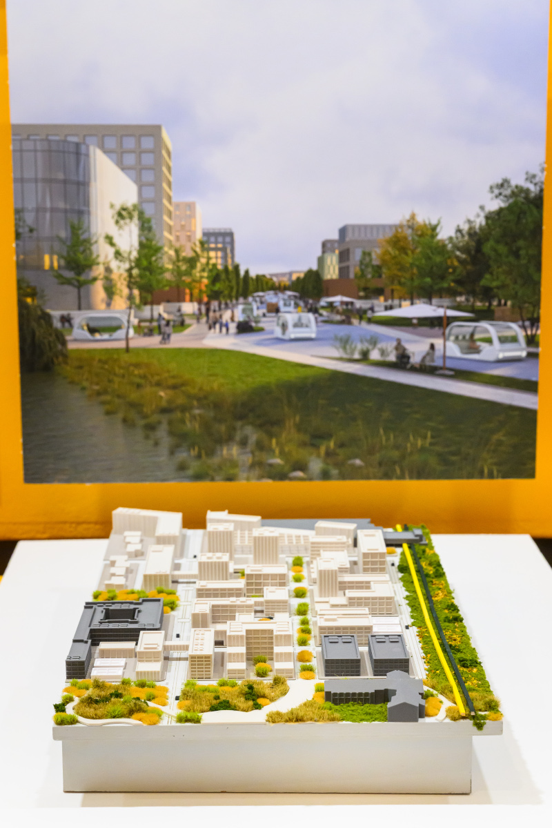 A landscape architecture model in front of a photograph on the wall.