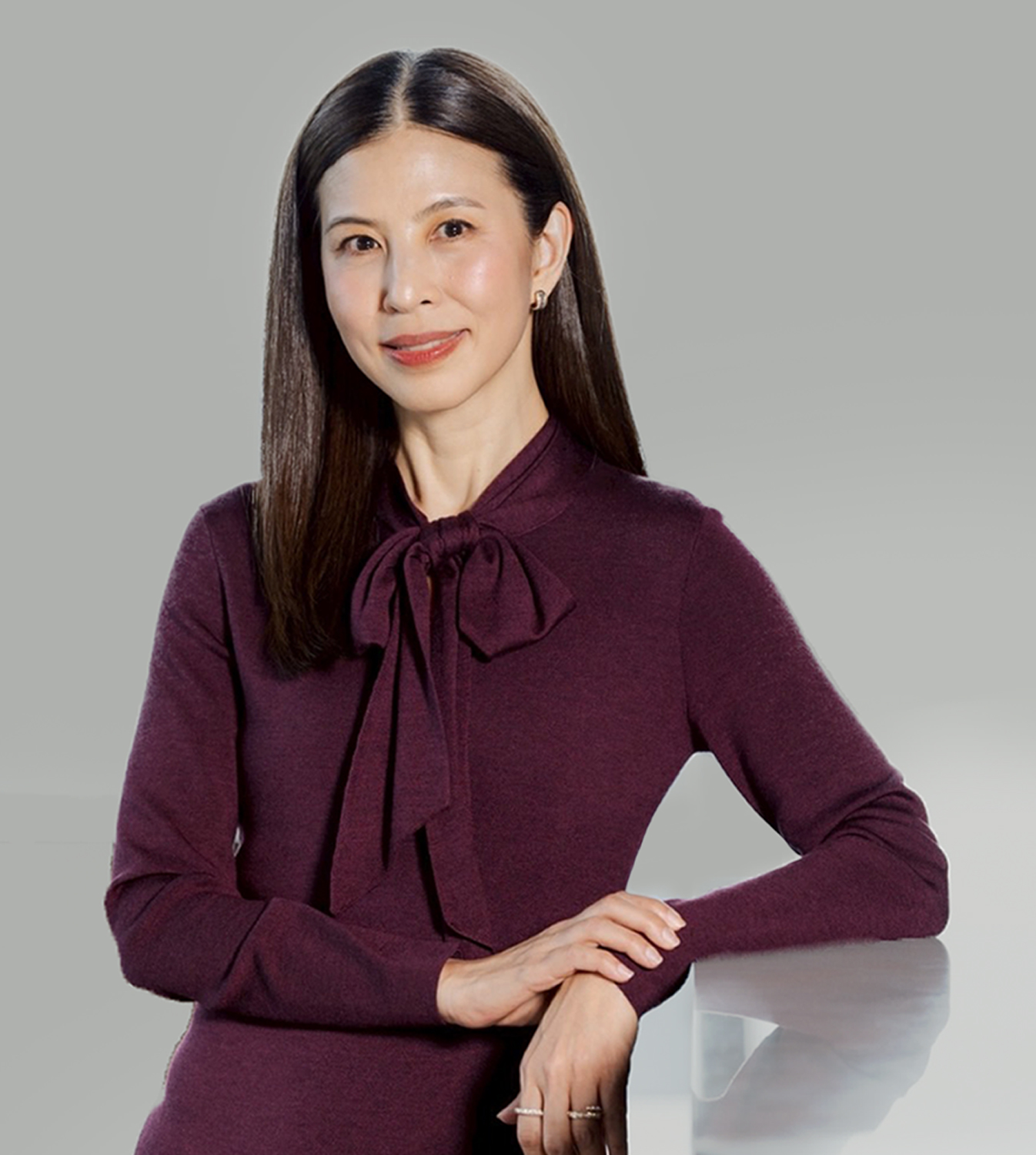 Woman in Burgundy shift standing and smiling.