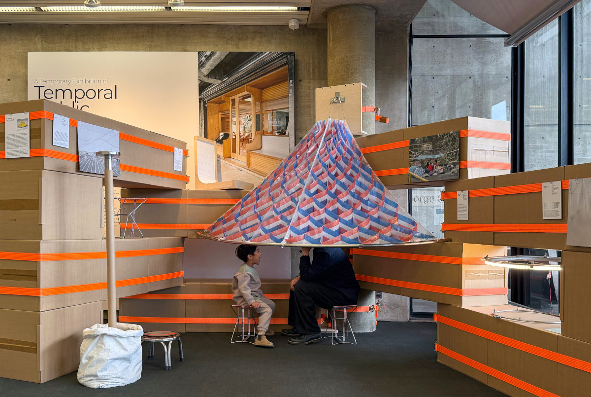 A seating area within a temporary structure built from cardboard boxes and ratchet straps in Frances Loeb Library.