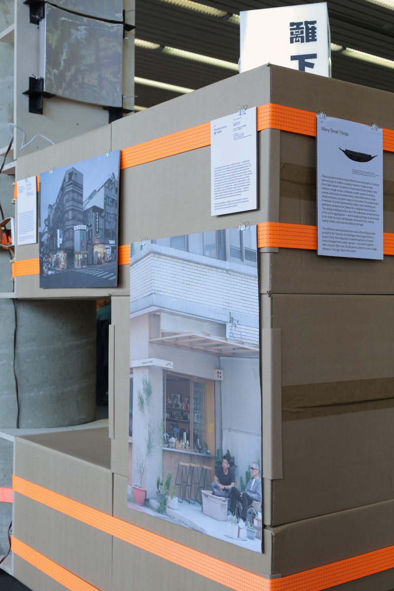 Images displayed on the surface of a temporary structure built from cardboard boxes and ratchet straps.