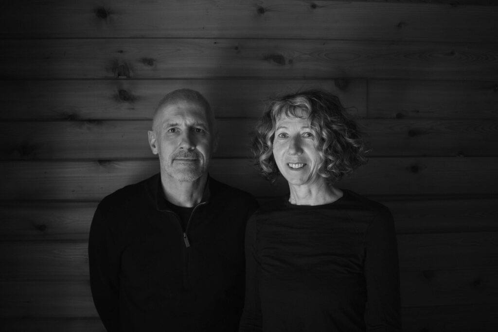 Anthony Dunne and Fiona Raby wearing black against dark background.