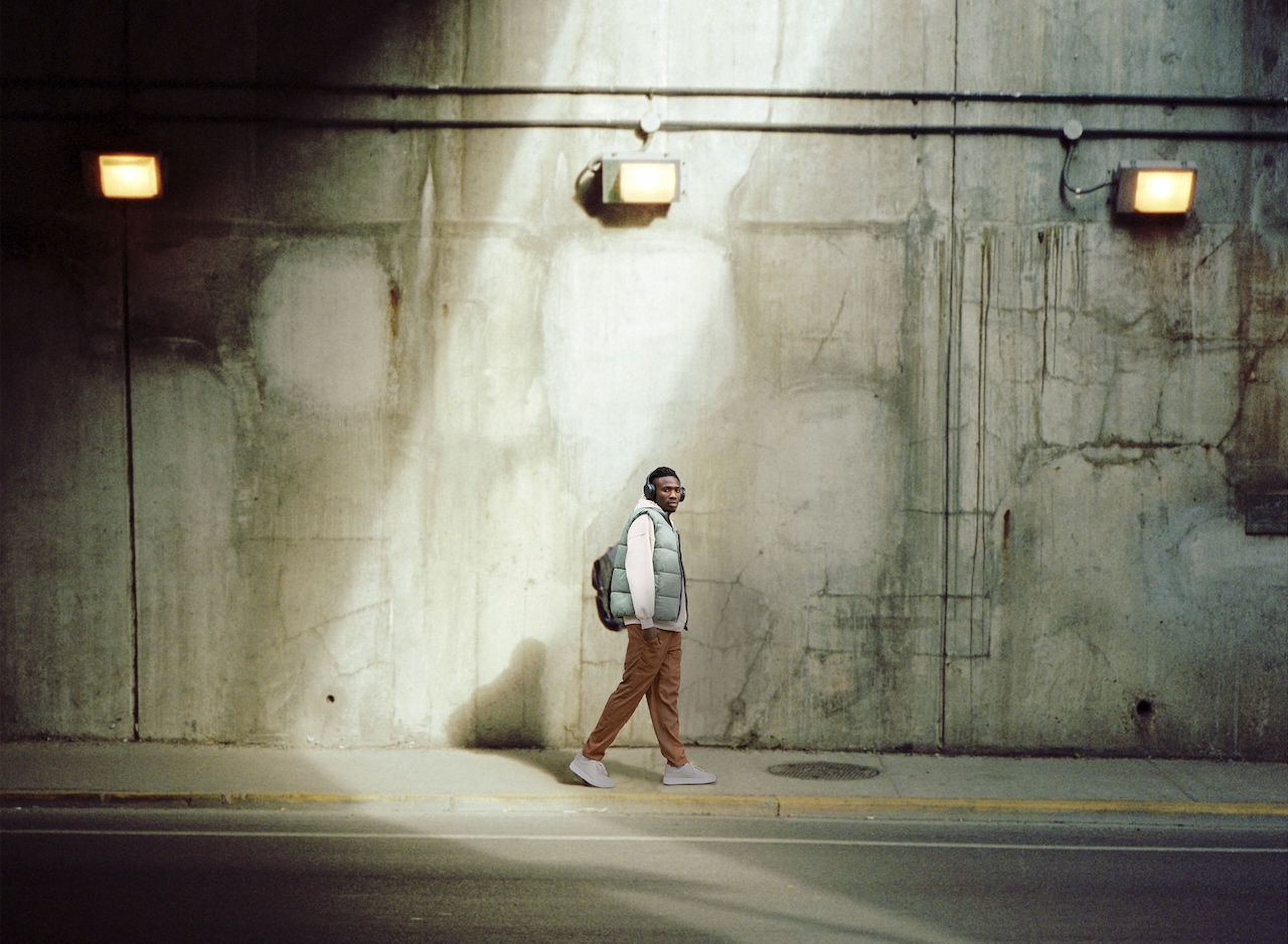 Photo of a man walking under an overpass.