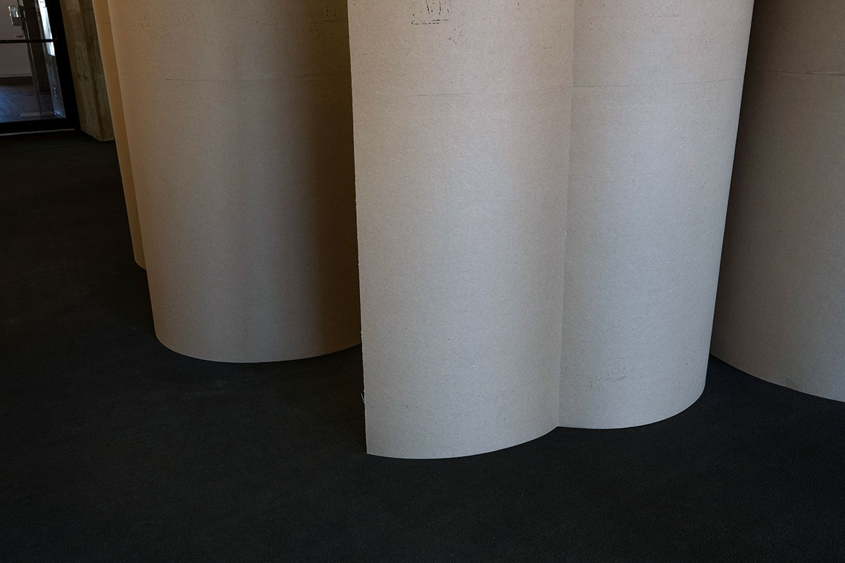 A temporary wall made of chipboard shaped into multiple curves.