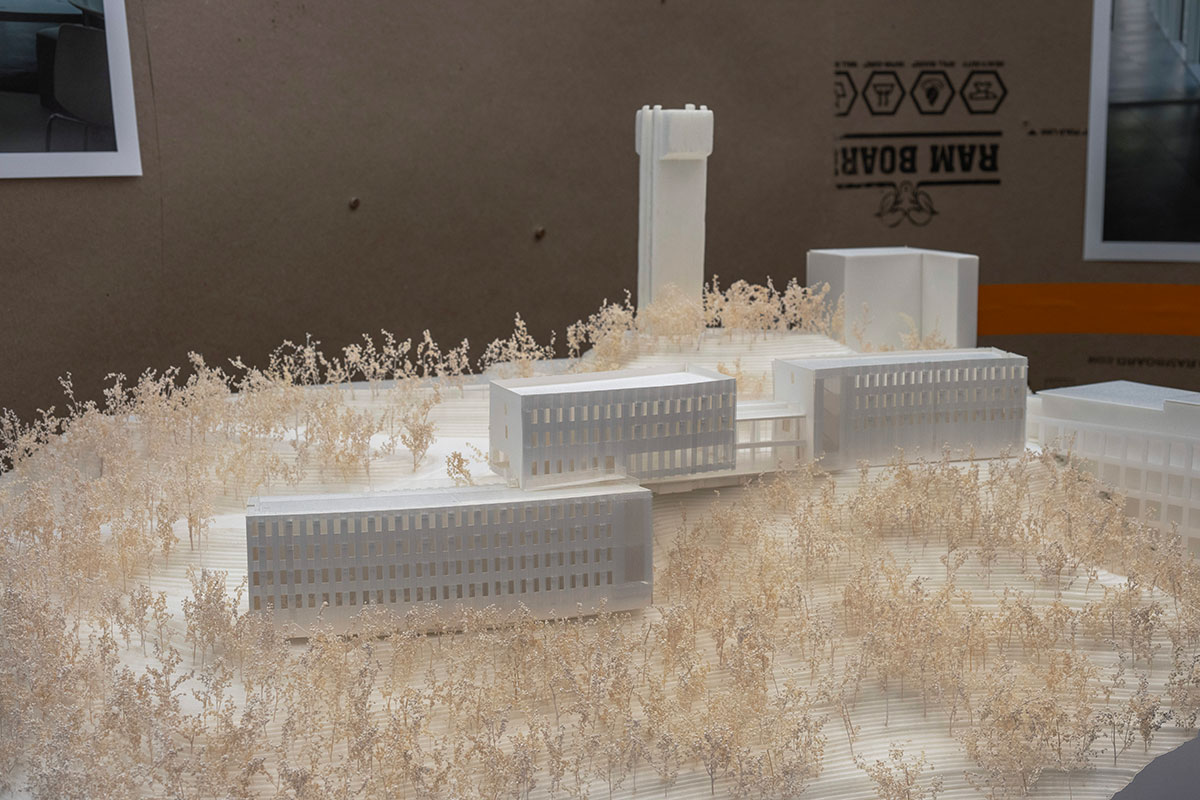 An architectural model of a building complex on a landscaped hillside.