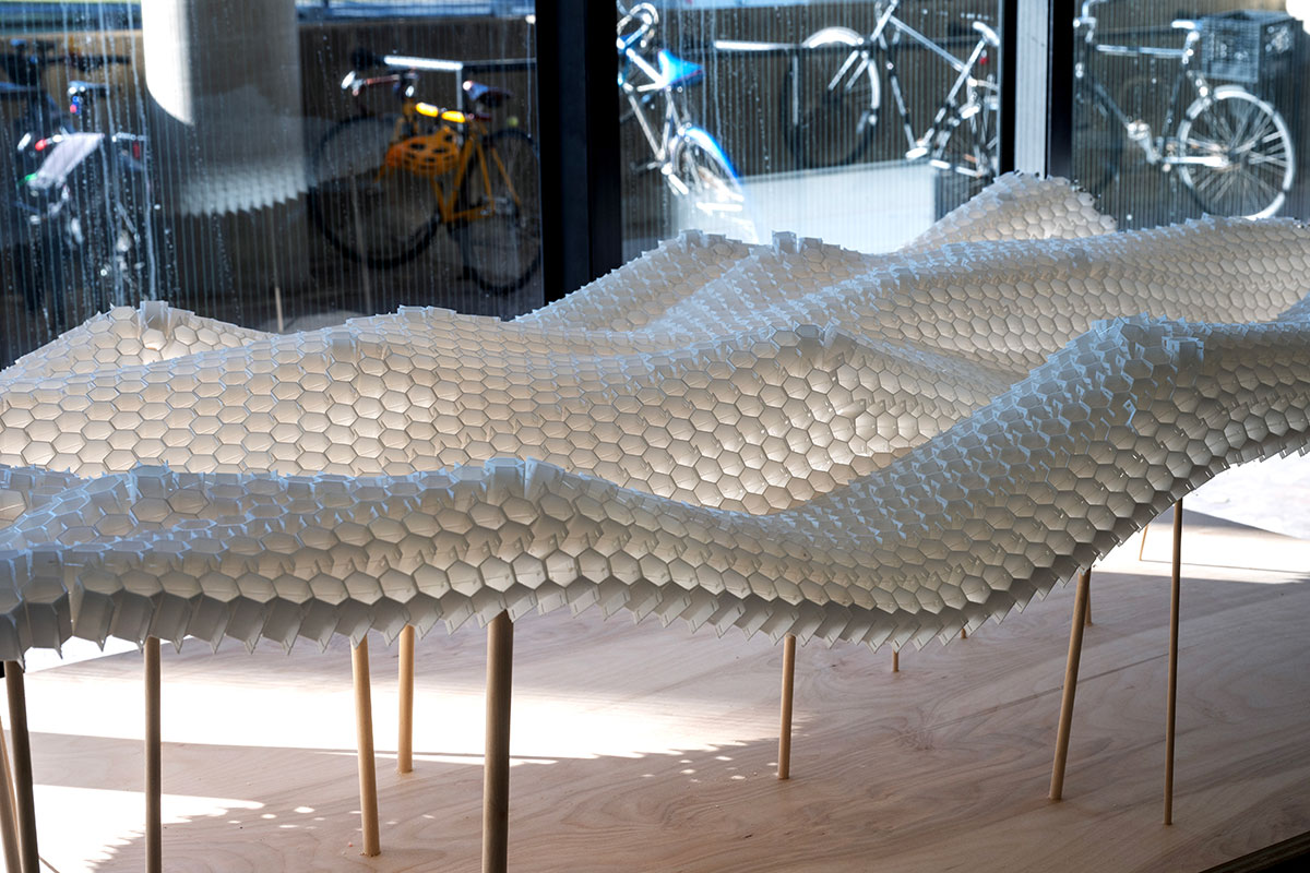 An architectural model of a curved form made of hexagonal shapes connected into a lattice.