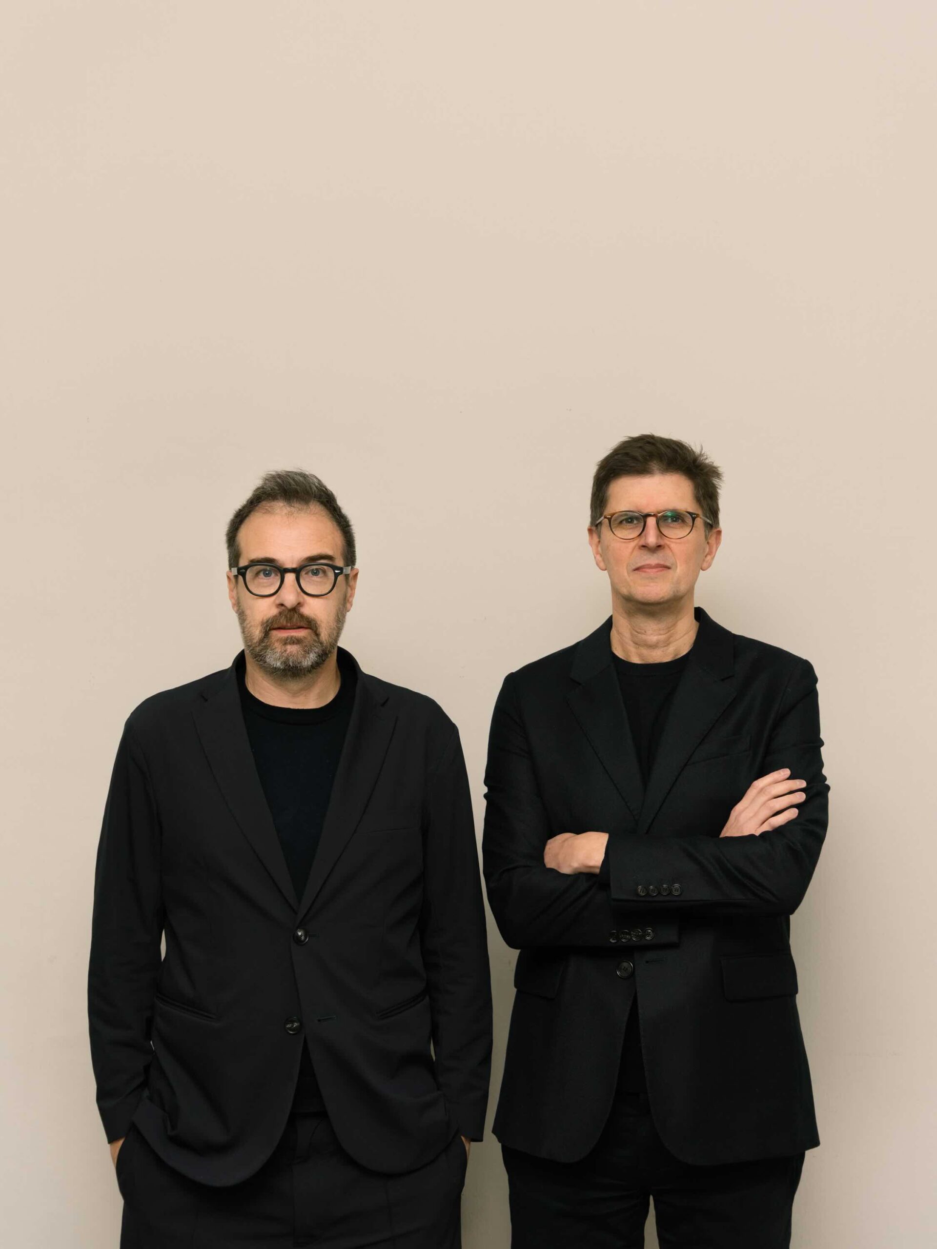Two architects wearing black standing side by side.