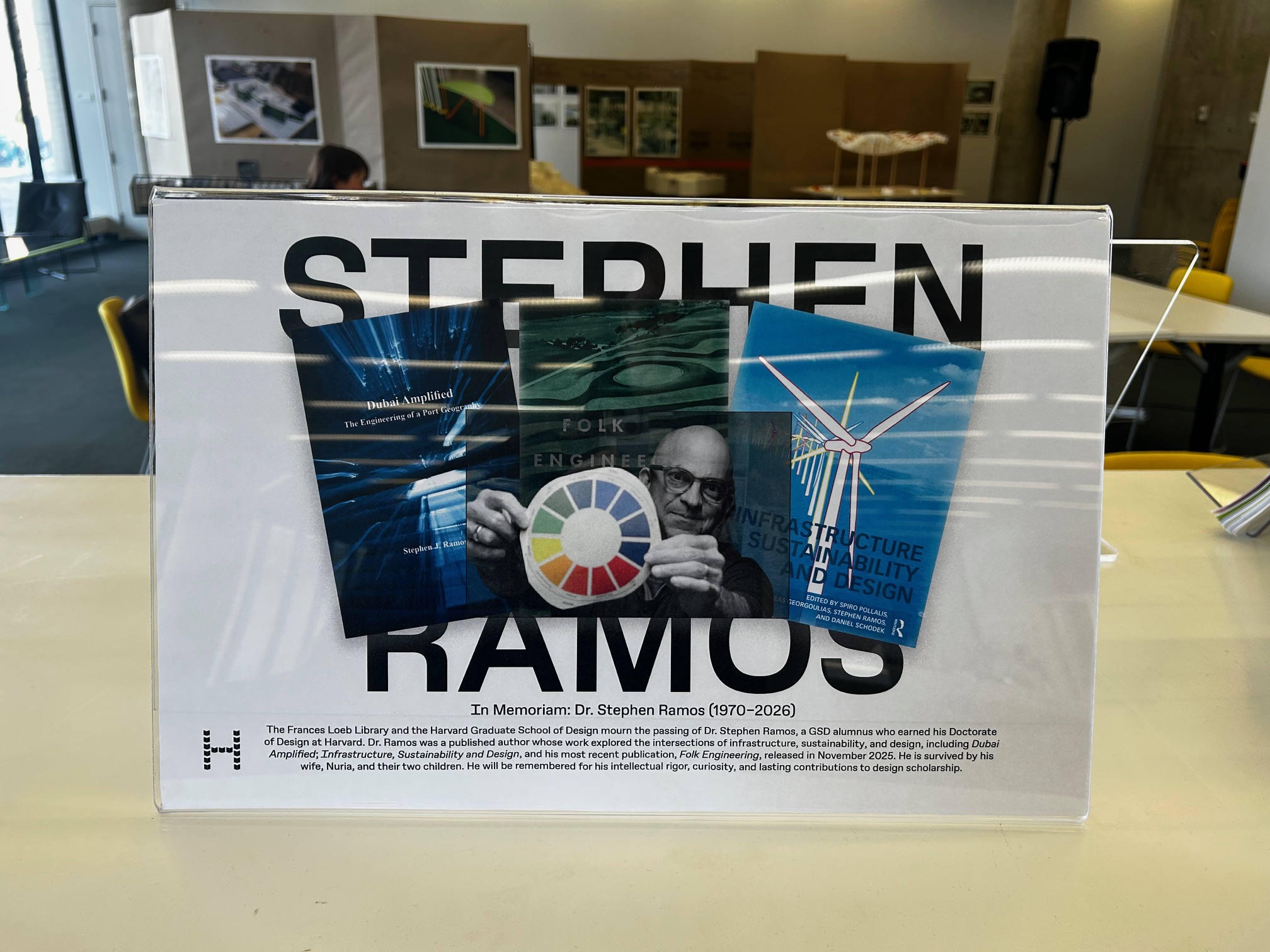 A sign in the Frances Loeb Library with an image of Stephen Ramos surrounded by his publications