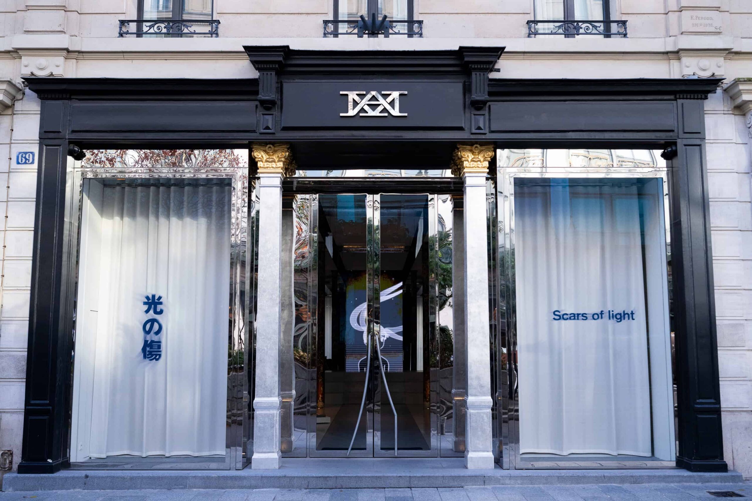 A building entrance with glass doors and silver and black columns