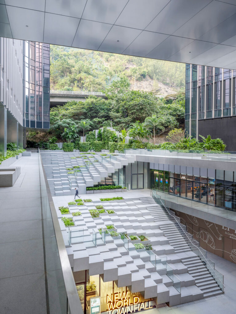 Cascading white stairs between two towers, with a lush garden behind.