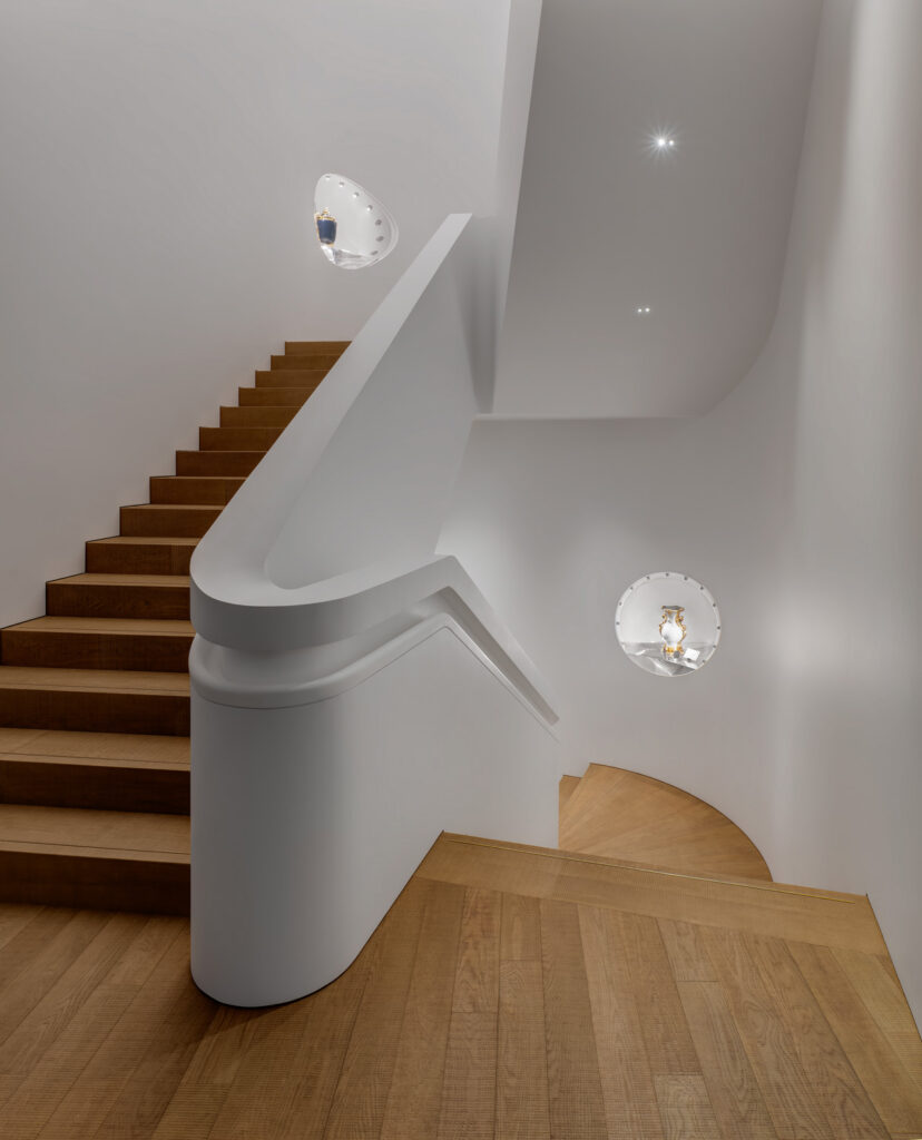 Wooden stairway with white walls.