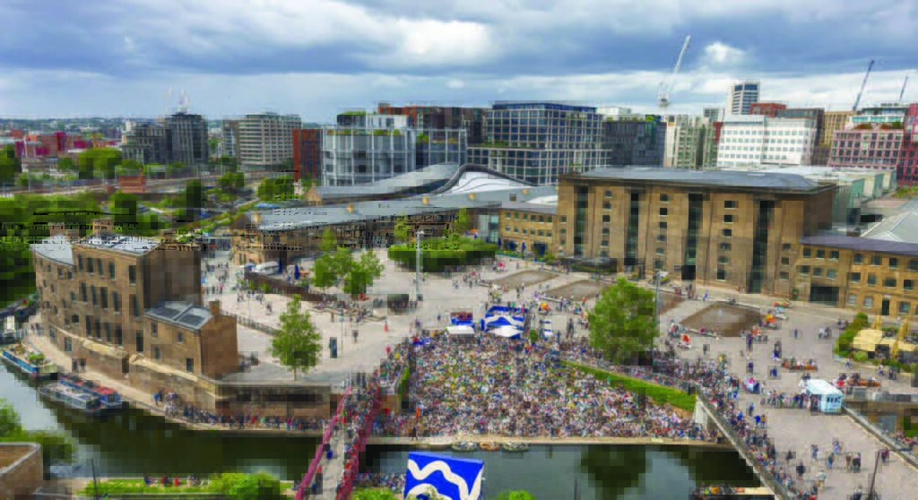 A public square in London with a crowd gathered at its center.