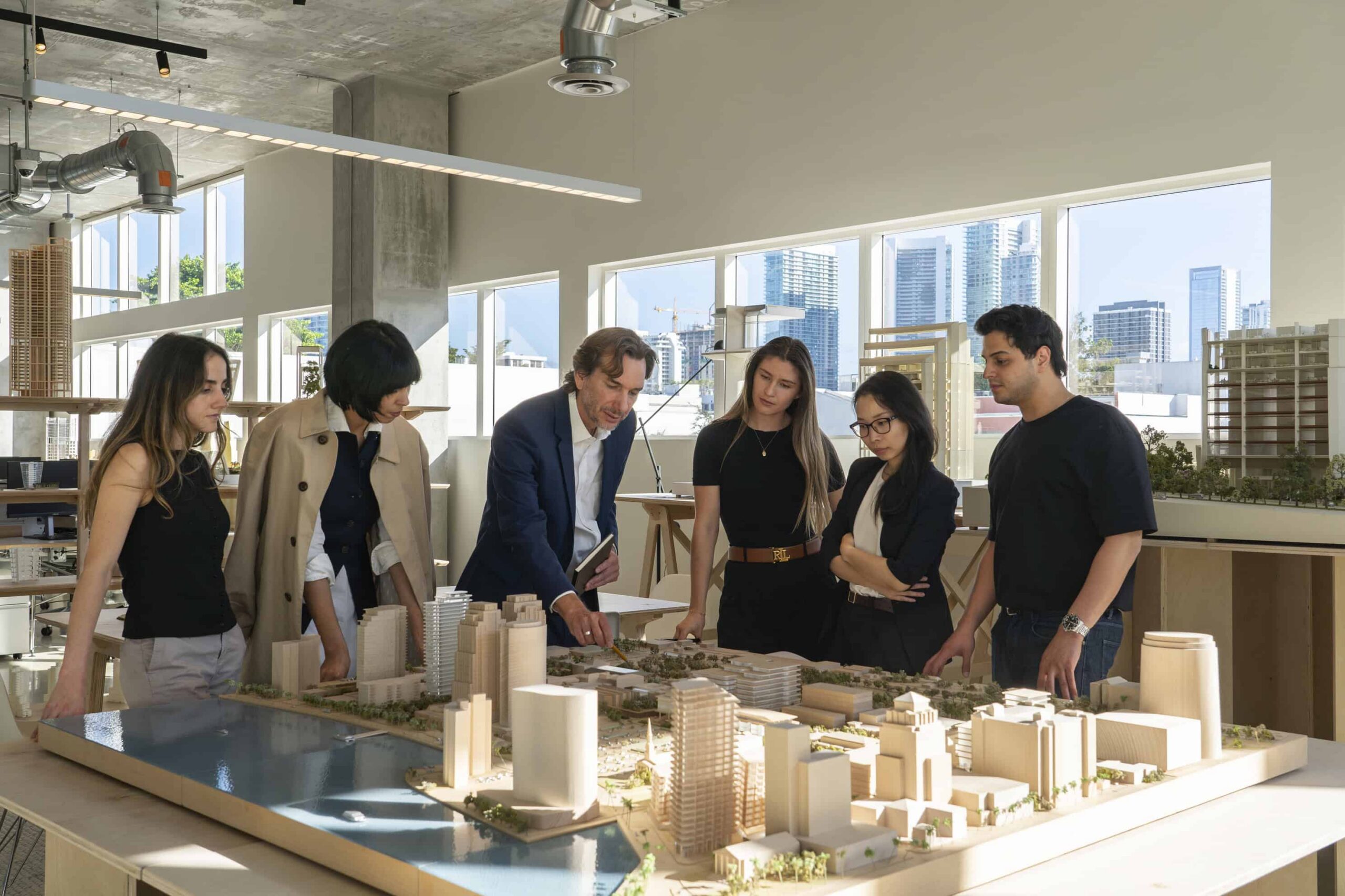 A group of people gather around a model smiling