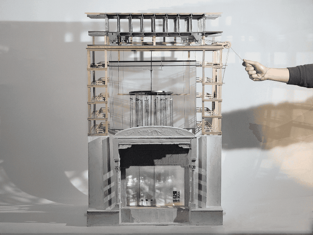 Model set for an opera including a stage and rafters above it.