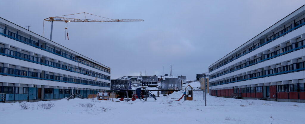 two housing blocks with snow covered playground.