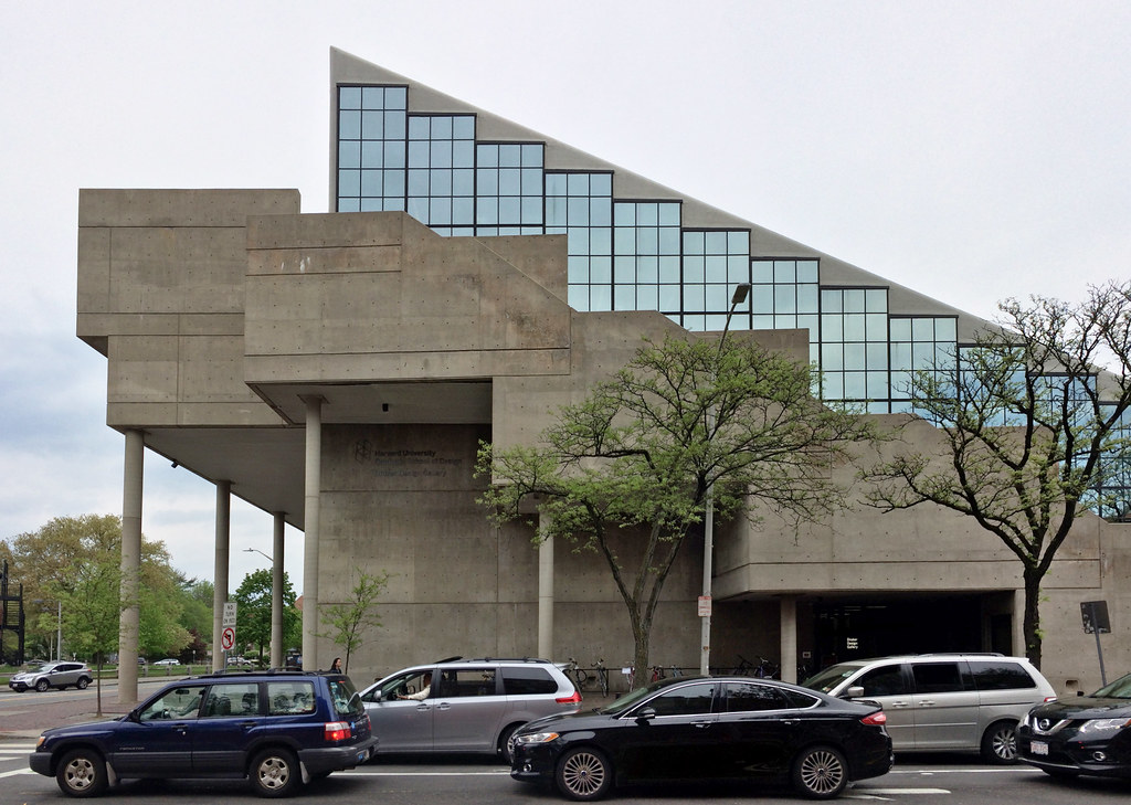 Cars drive past the exterior of Gund Hall.