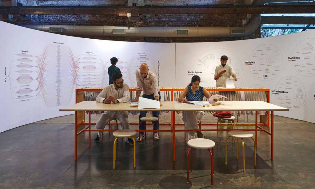 People sitting at a table with diagrams on the walls behind them.