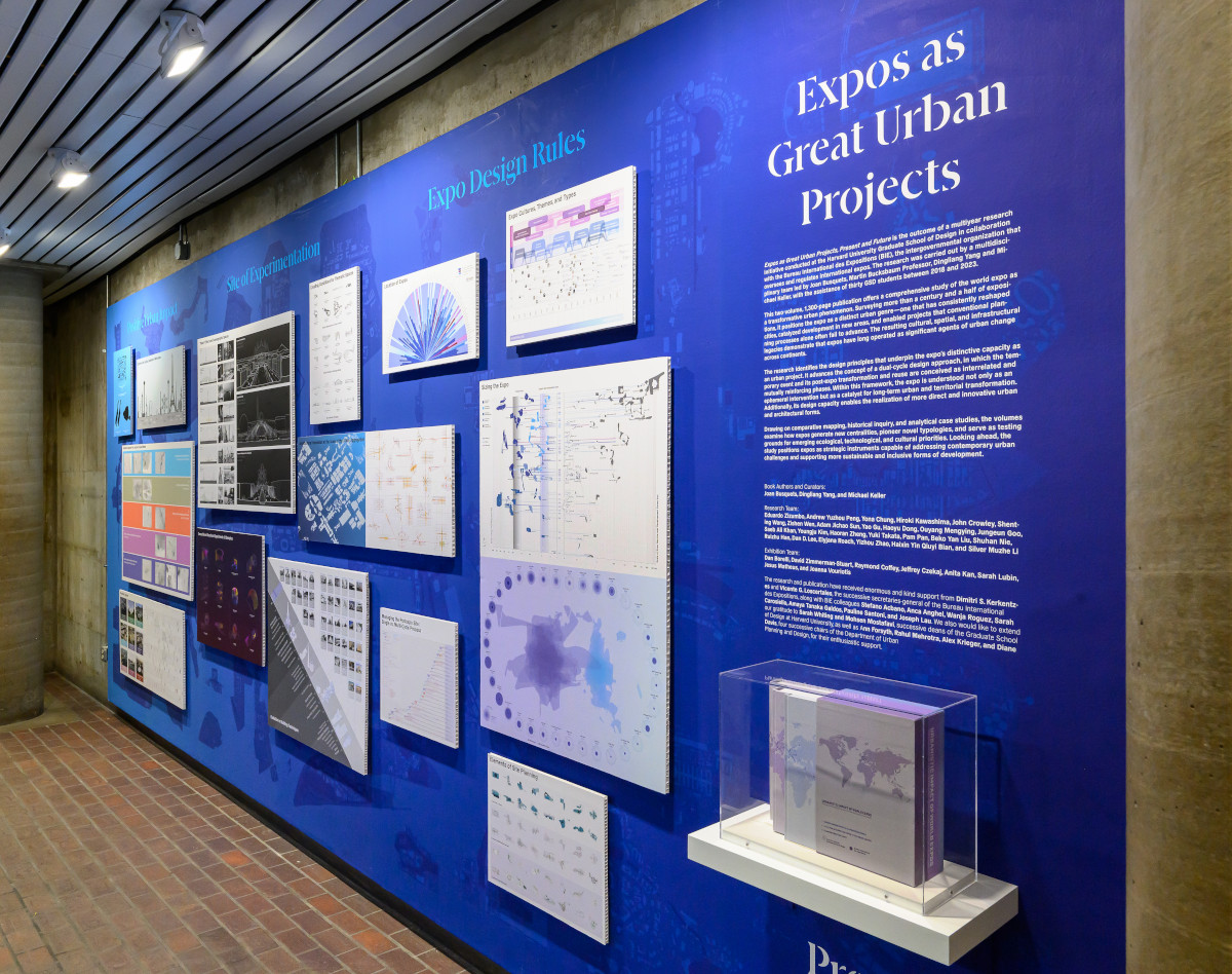 A blue wall displaying a variety of informational drawings and a shelf with a set of books.