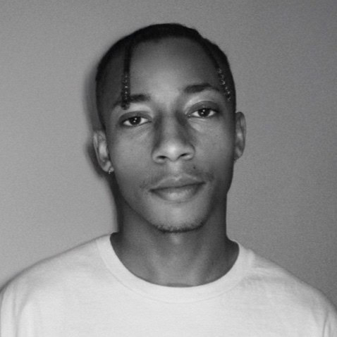 Headshot of Tyler Simon with grey background.