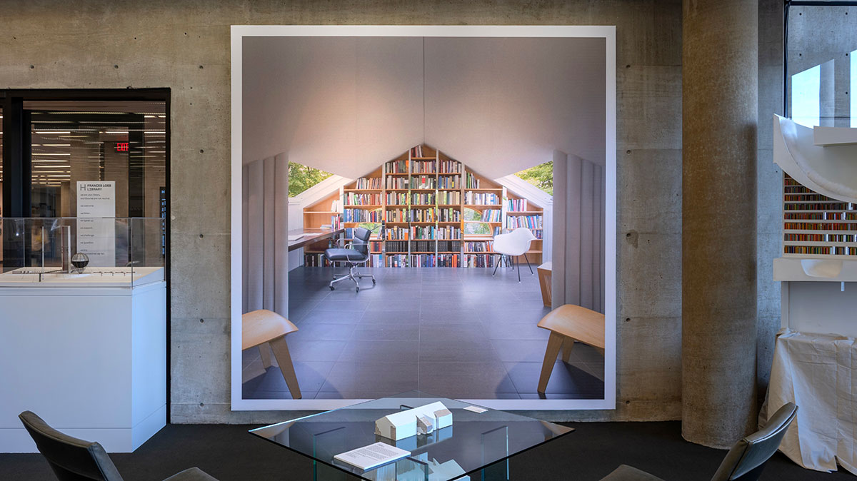 A large mural image of an interior with seating and bookshelves, in front of a seating area in Frances Loeb Library.
