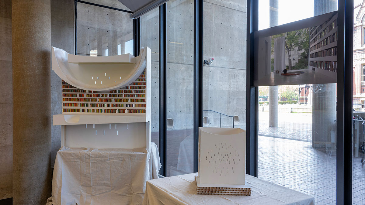 Two architectural models on tables in front of the windows in Frances Loeb Library.