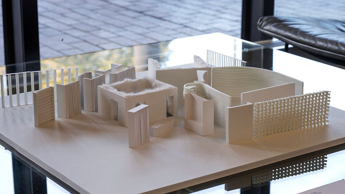 An architectural model of a collection of single story walls and entryways.