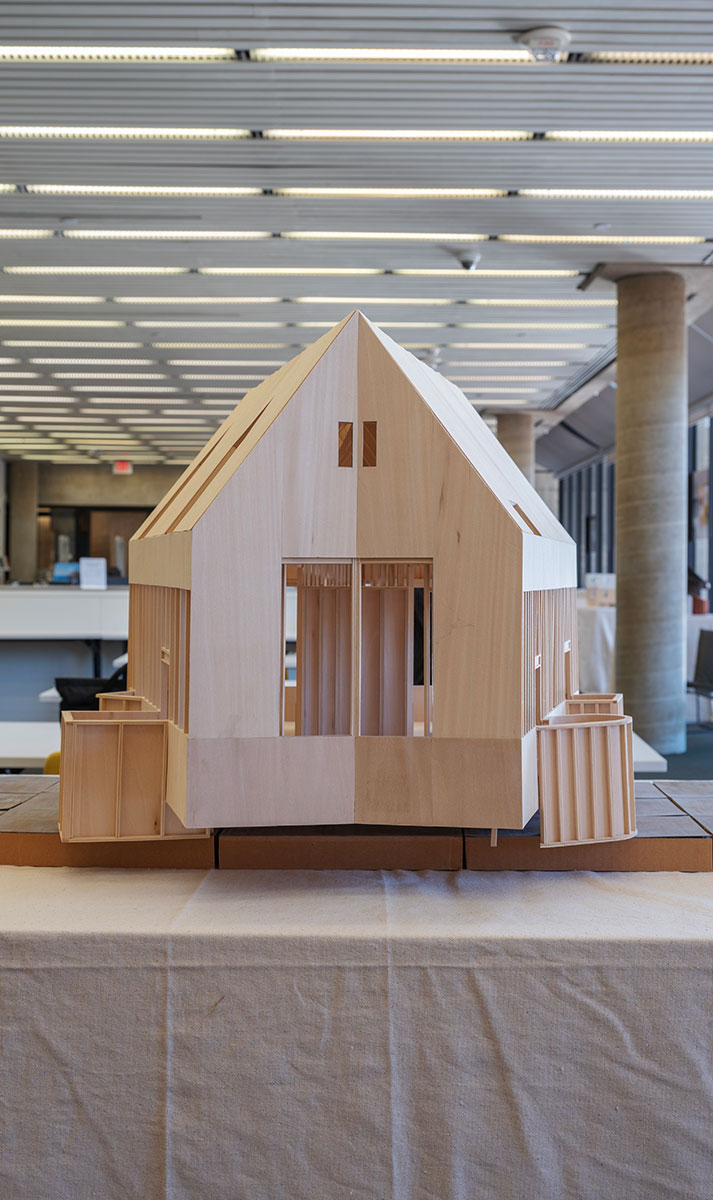 A wooden architectural model on a table draped with canvas, in Frances Loeb Library.