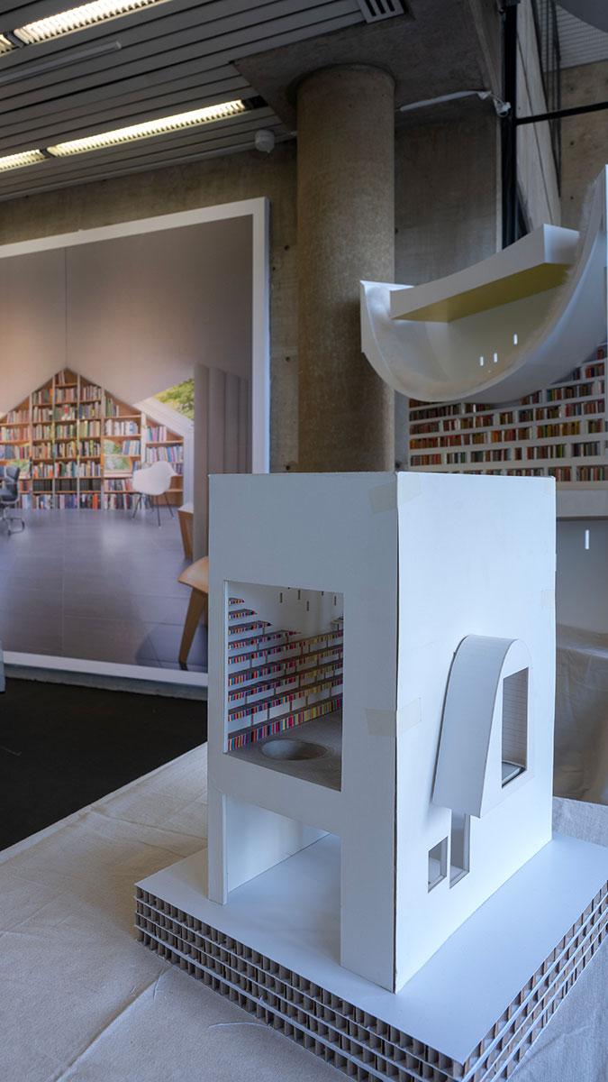 Architectural models showing buildings with bookshelves inside.