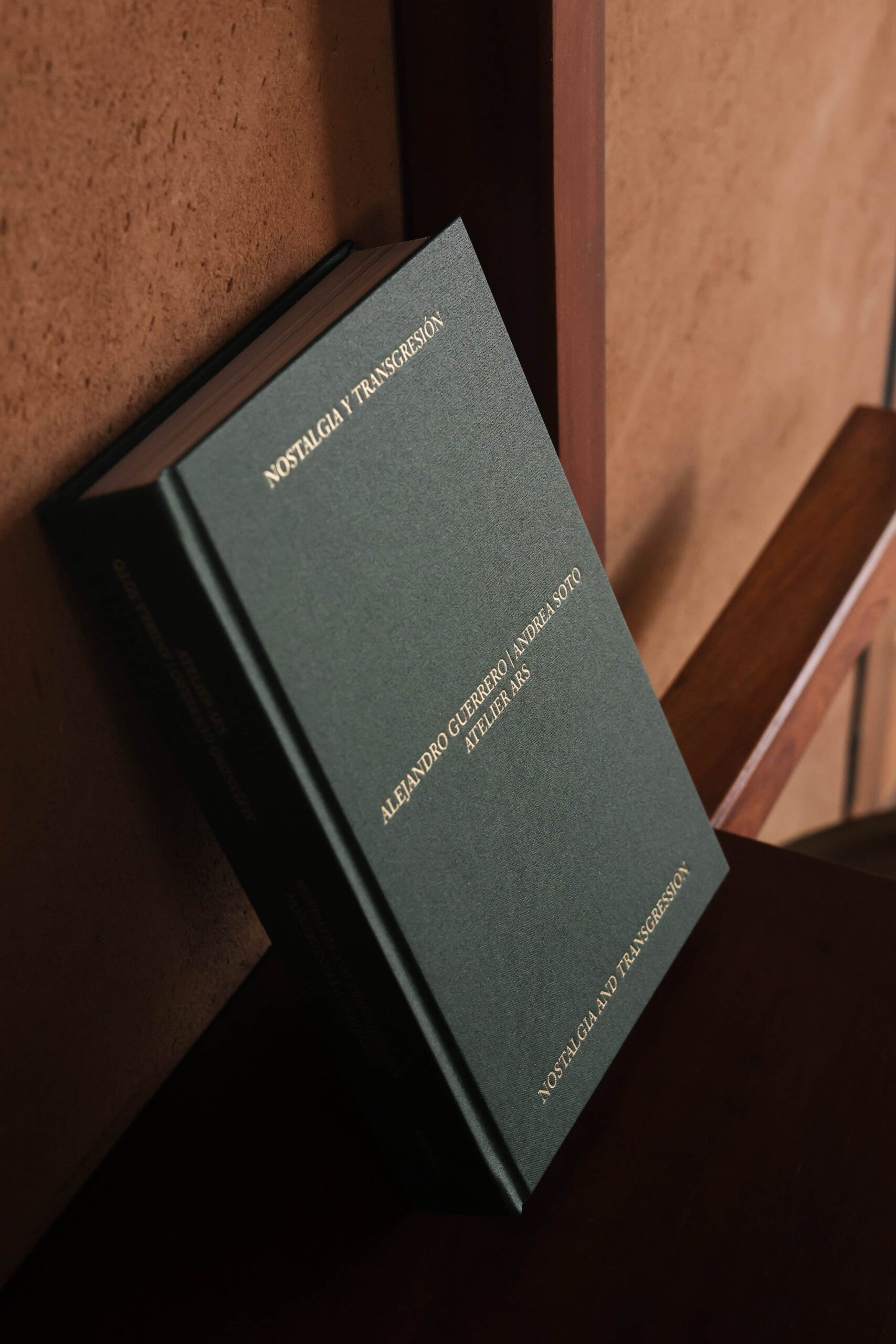 Green book leans against a brown wall