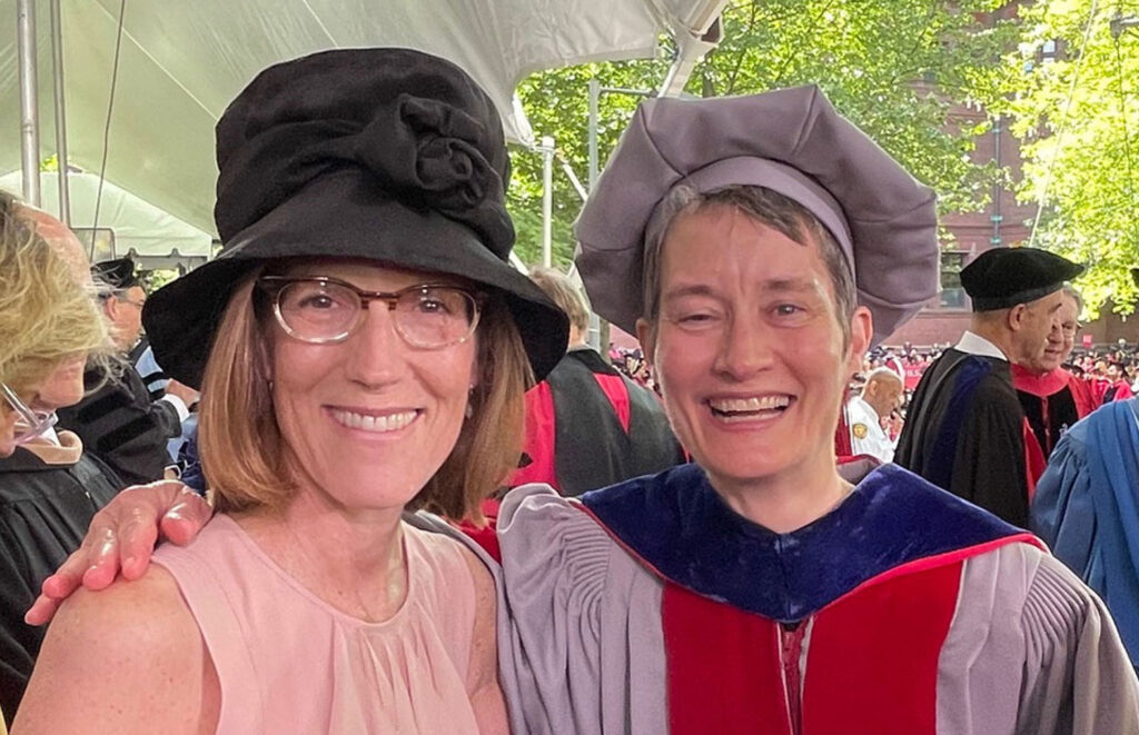 Two women in large hats smiling.