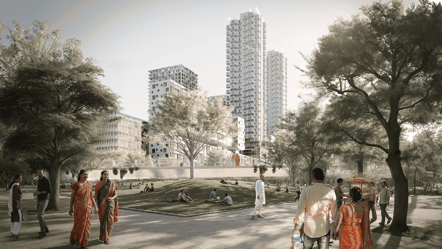 A park setting with people walking and sitting on the grass. Tall buildings rise in the background, surrounded by trees. The atmosphere is calm and relaxed.