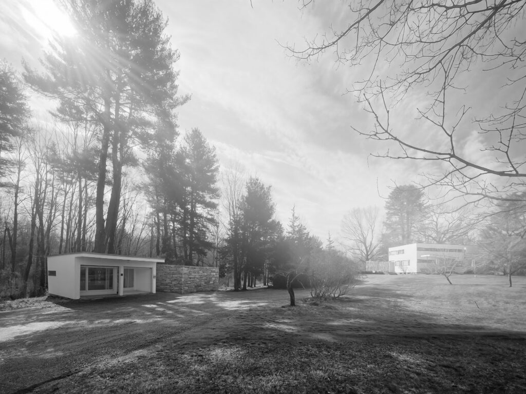 Black and white view of site with White House and garage and woods.
