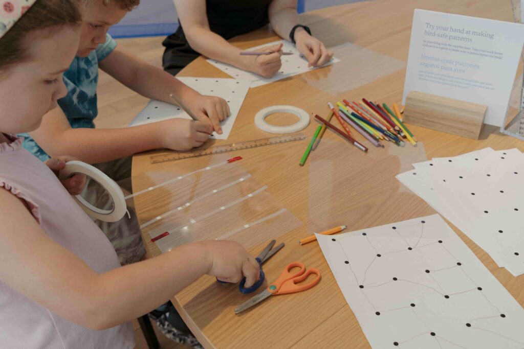 Children make 2 inch by 2 inch marks for bird-safe glass