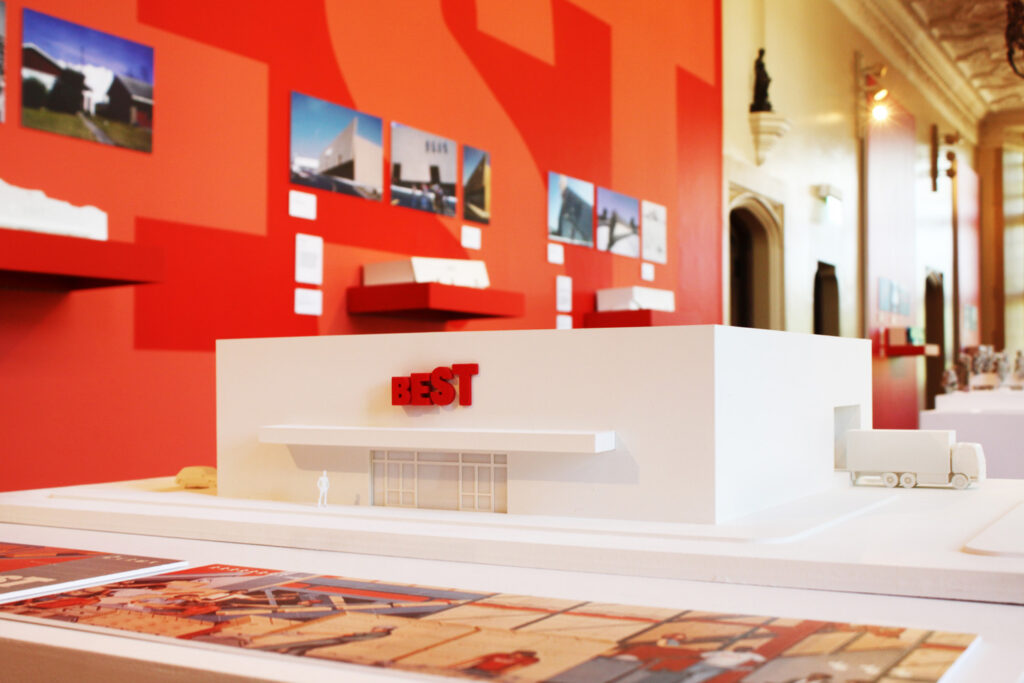 View of white building model with red sign.
