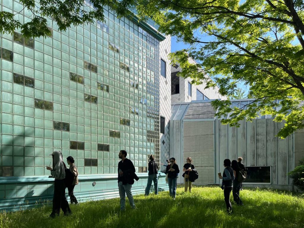 Green glass block wall with people standing in front of it.