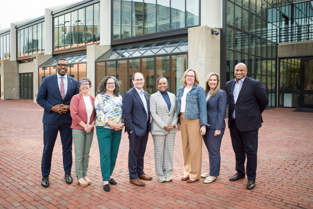 A group of eight mayors posing in front of the GSD's Gund Hall.