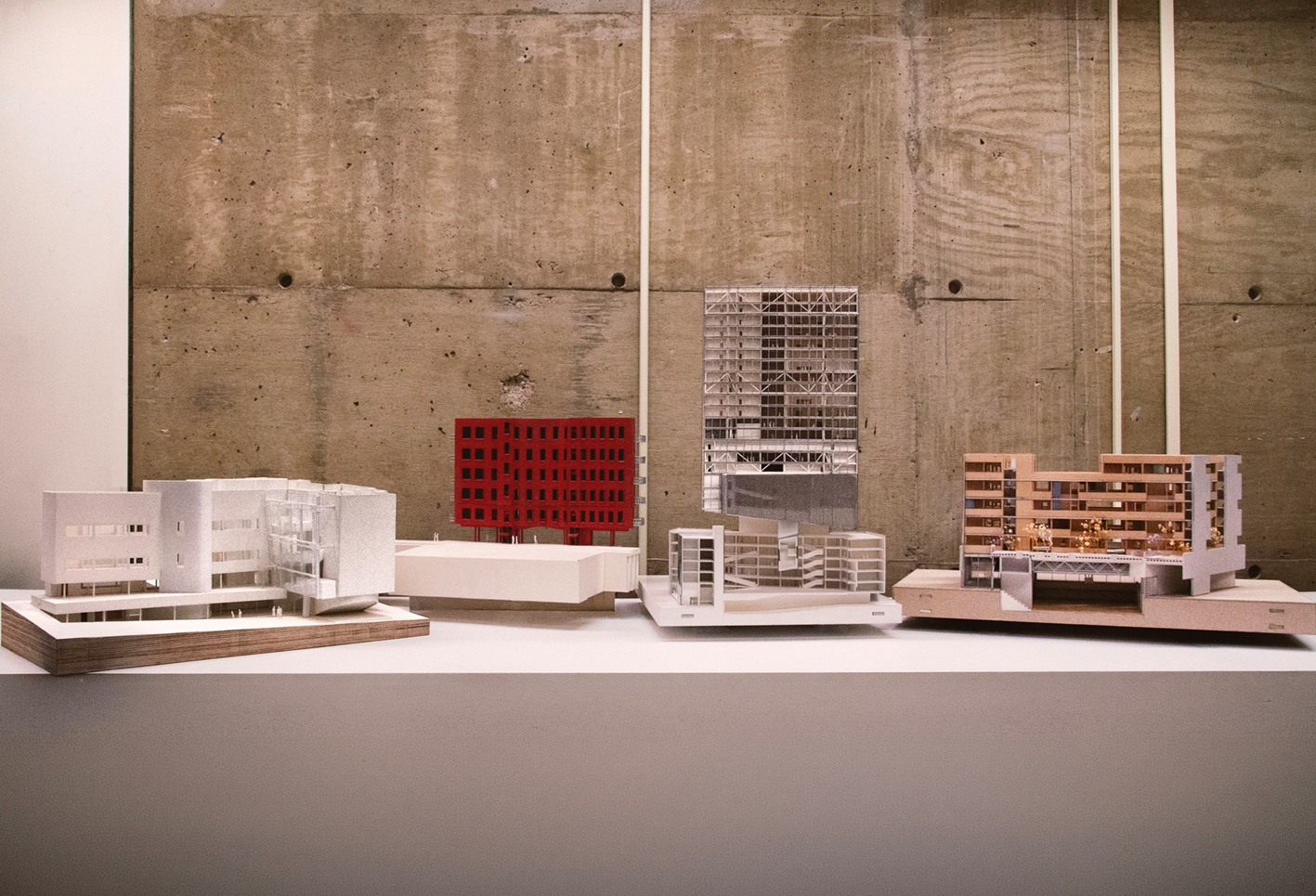 Four architectural models presented on a white plinth.