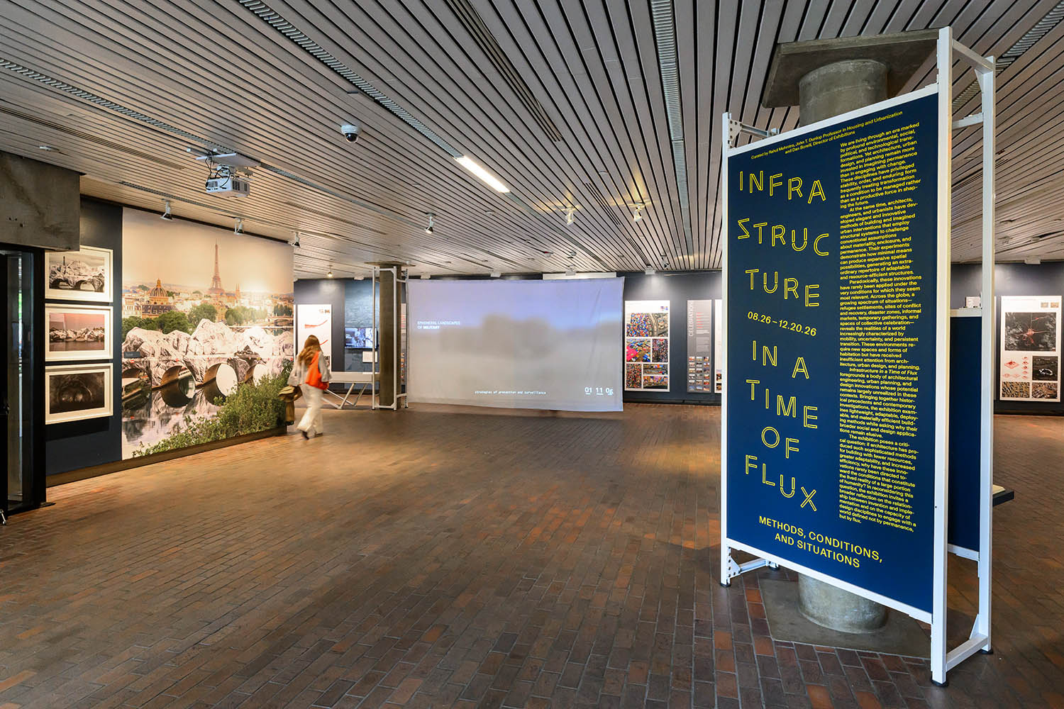 An over-all view of a gallery with a large graphic, a projection screen and title panels.