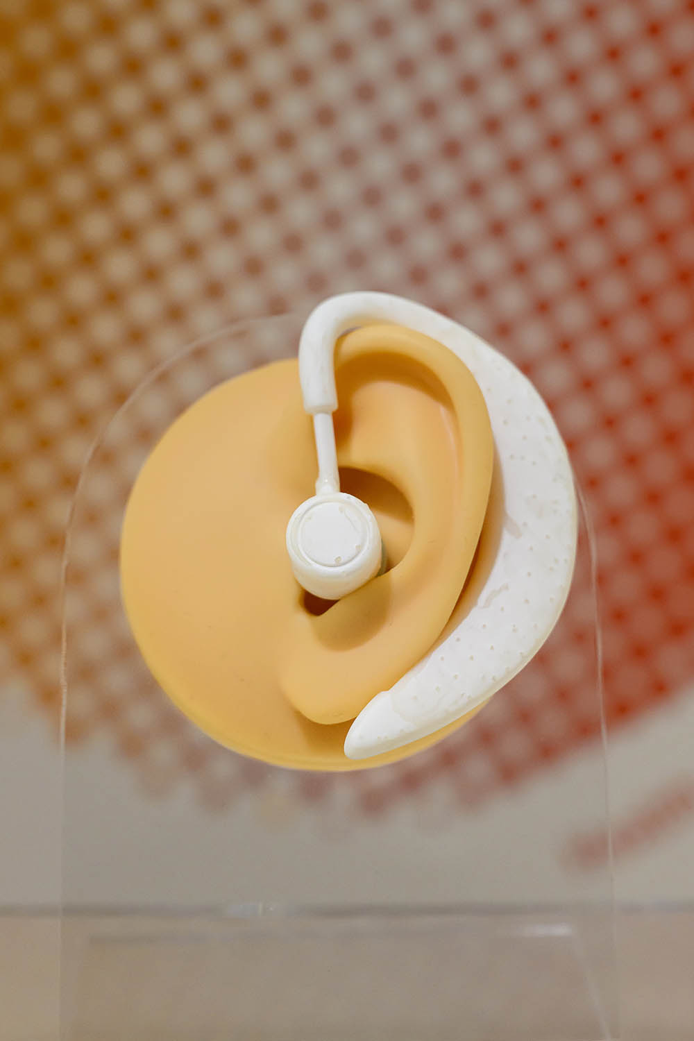 An audio device mounted on an artificial ear.