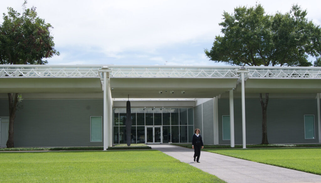 Horizontal building with grass and trees.