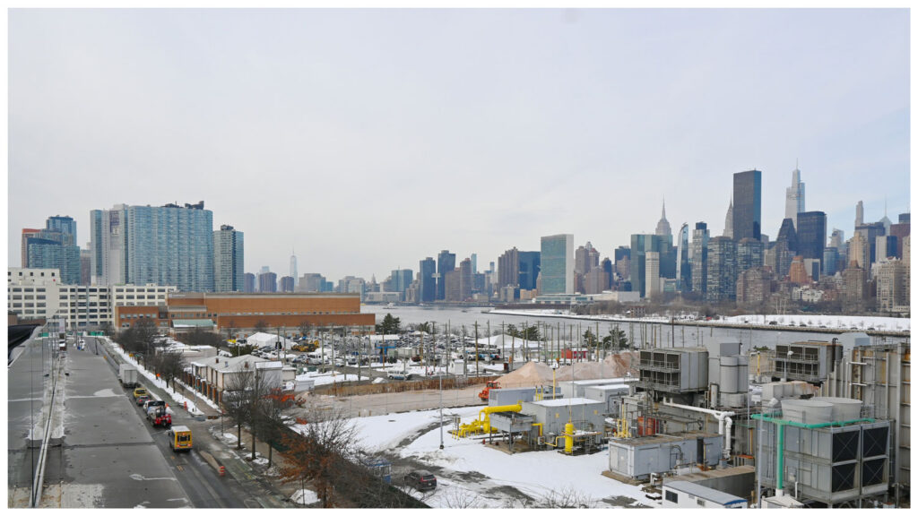View of industrial coastline with city beyond.