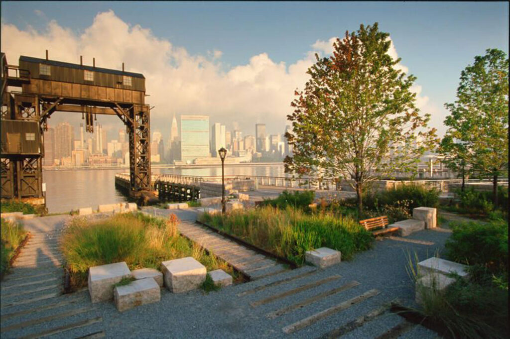 View of park, gantries, and river with buildings beyond.