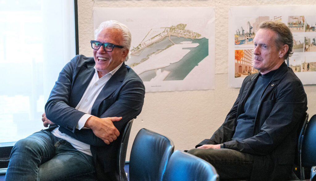 Two men sit in chairs.