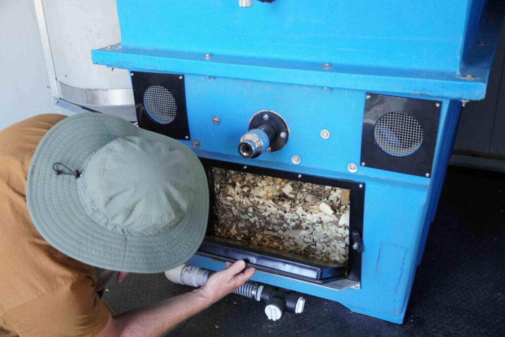 a person looks at a composting machine
