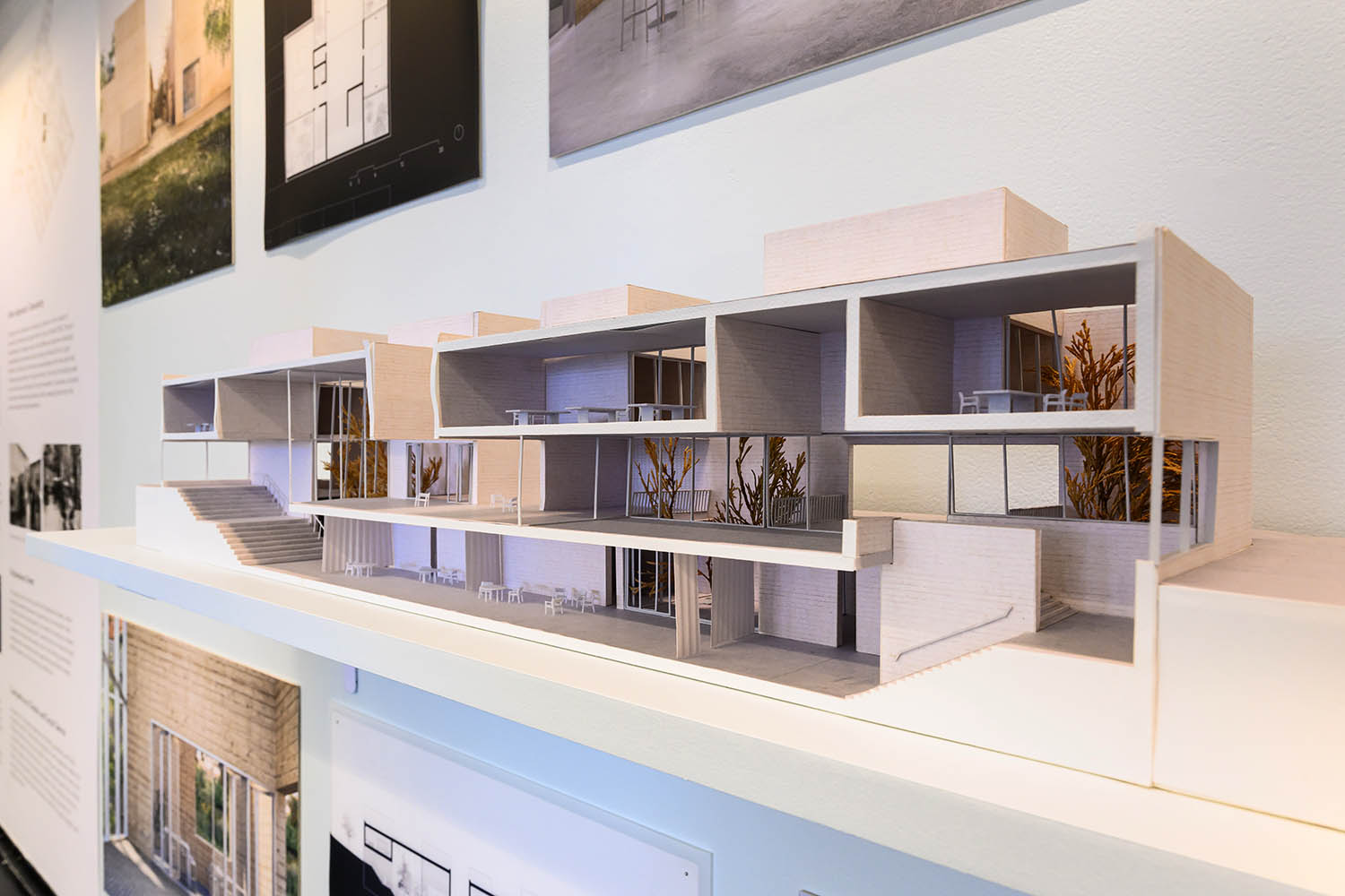 Two halves of a model displayed so you can see the inside on a long shelf mounted in the center of the exhbition wall