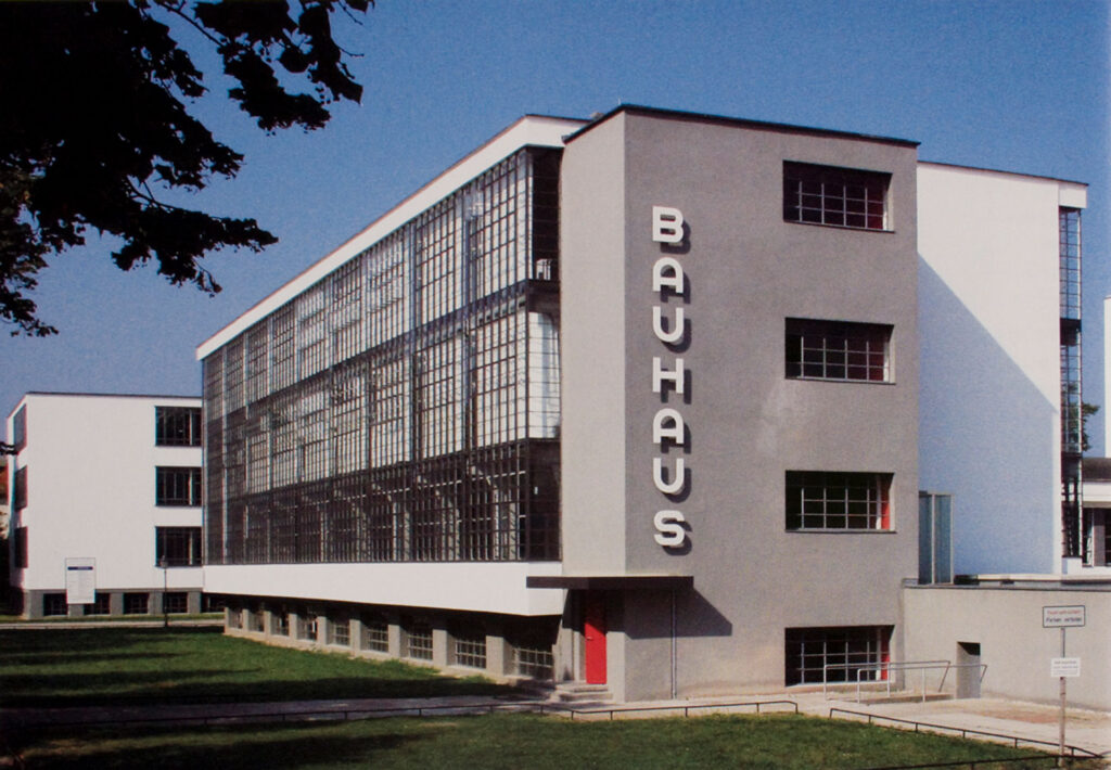 Gray and white and glass building with large clean writing on the side.