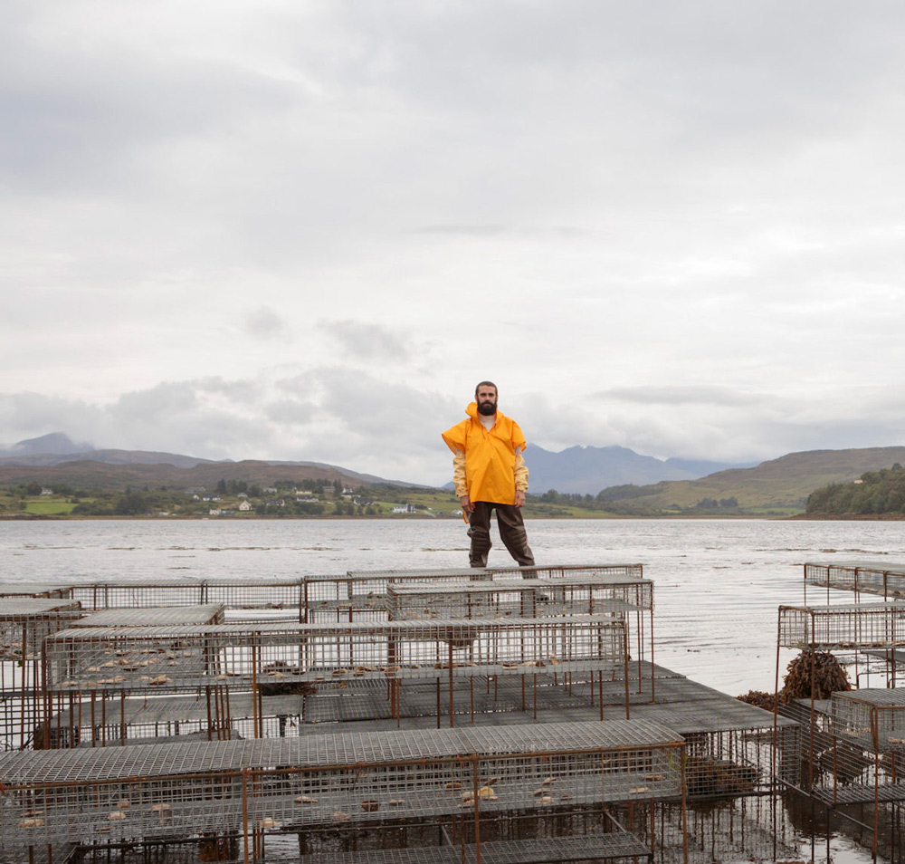 A man stands on a dock surrounded by traps.