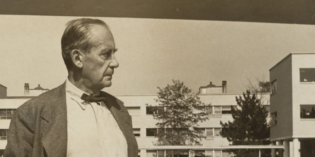 Man stands in front of modern looking building.