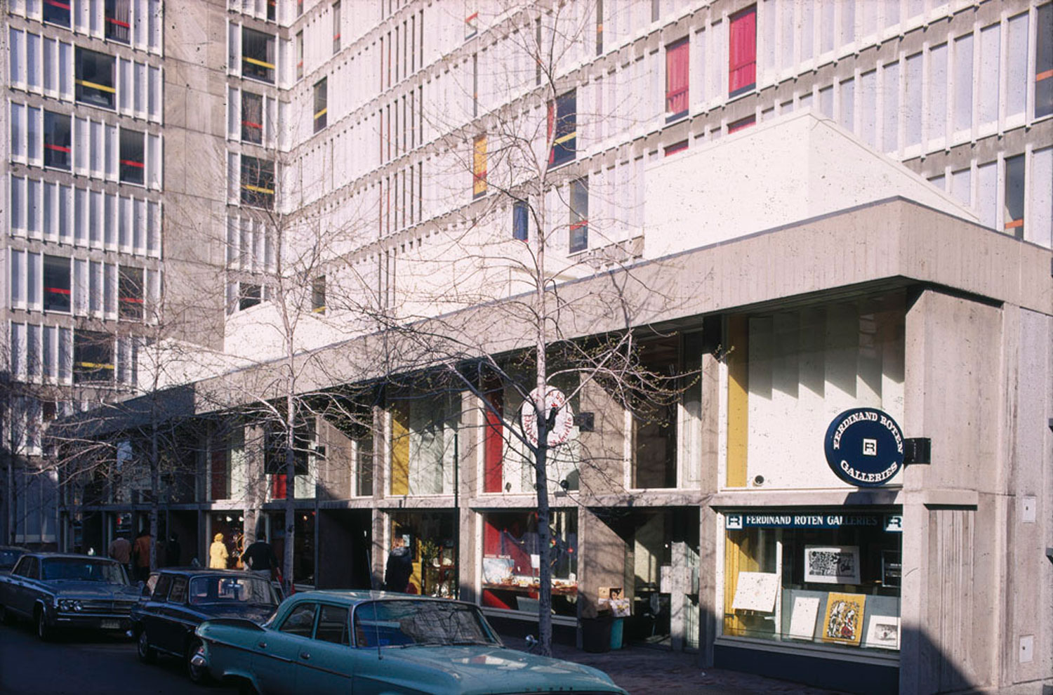Concrete building with colorful panels and shops signs.