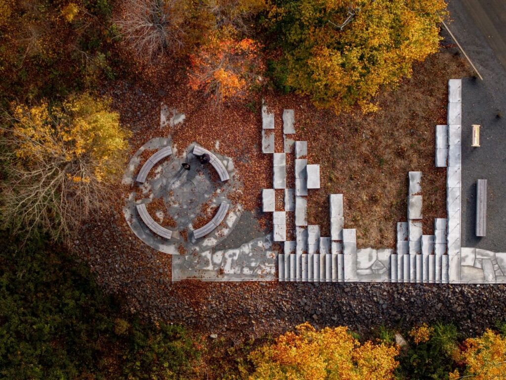 an aerial view of a stone formation partially covered by orange autumn leaves