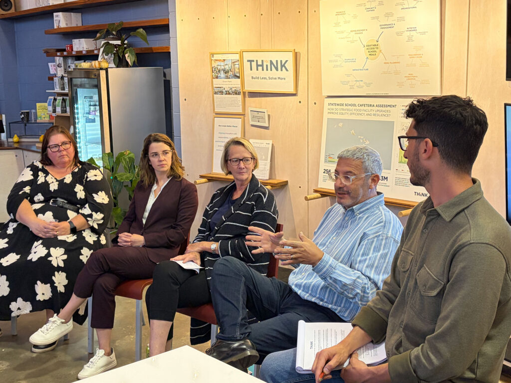 Five people in a casual environment talking on a panel.